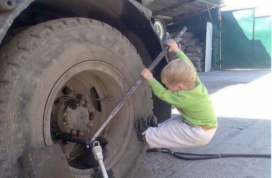 Kid fixes truck wheel 