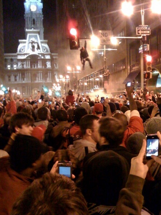 Guy hanging on lamp post